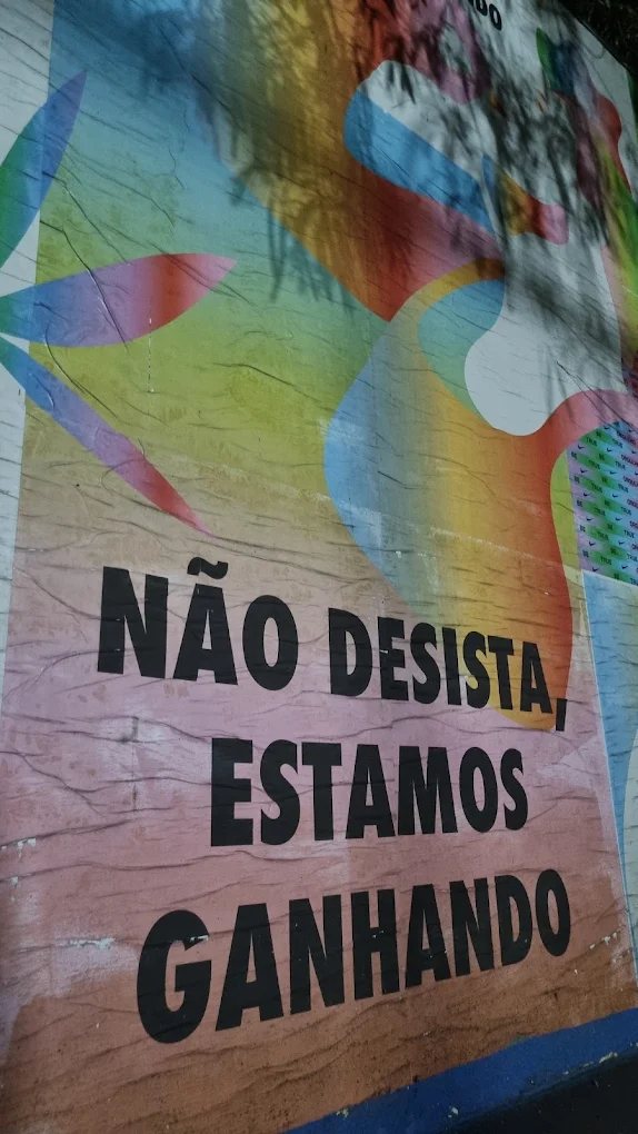 Mural colorido pintado em parede da casa com a frase Não desista, estamos ganhando.